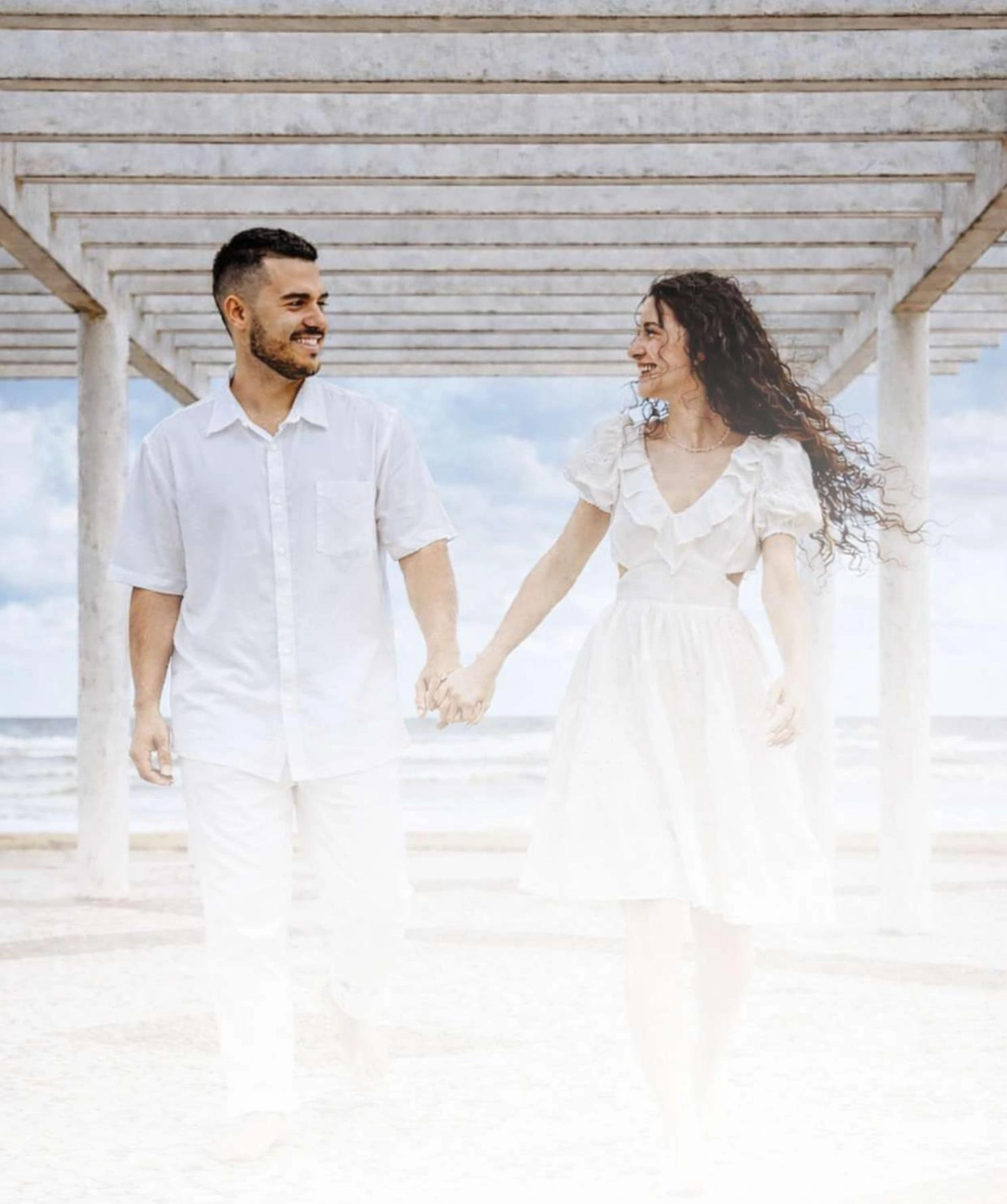 A couple walking hand in hand by the sea